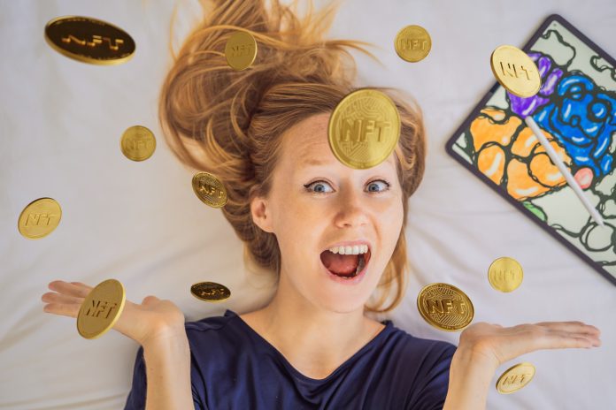 NFT Young woman, a digital artist, creates digital art on a tablet at home and shows a coin with the inscription NTF - non fungible token. Remote work, digital nomad, digital painting, animation, video