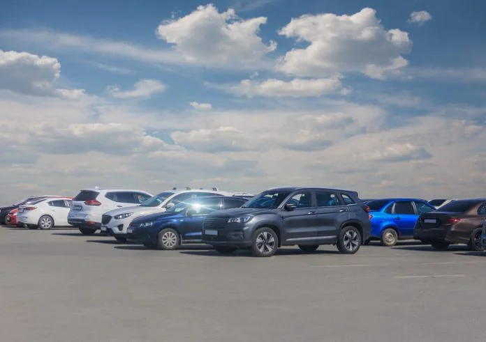 Cars in parking lot under cloudy sky automotive advertising