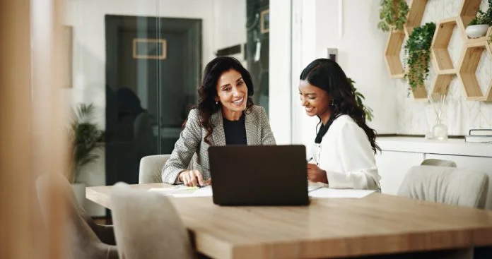 Meeting, women and business people with laptop in office, investment project and discussion. Teamwork, accountant and financial advisor with feedback for finance update, report review and documents Employer and an Employee