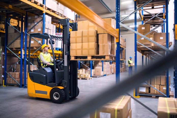 Young warehouse workers working together.