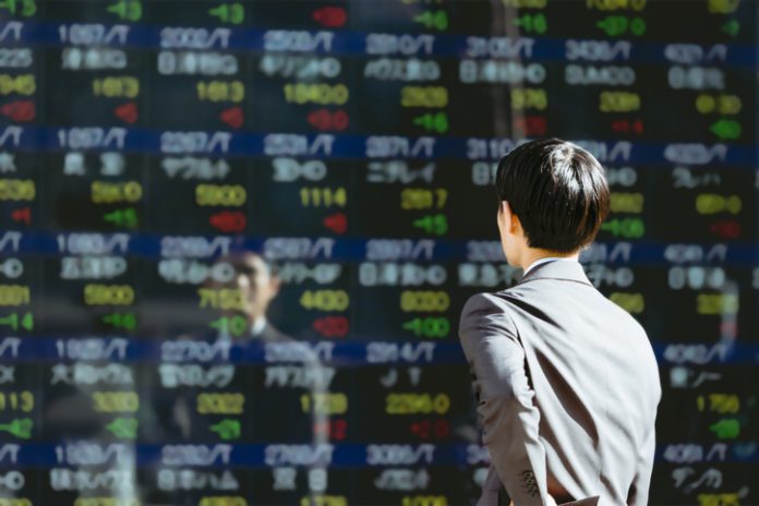 See the electronic bulletin board on an outdoor stock board A businessman investor male in the 30s
