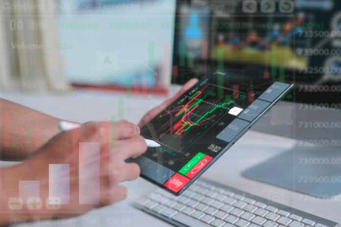 investment and finance concept, businessman using pen and computer tablet woking or analysing on virtual trading graph background, stock market, profits and business growth