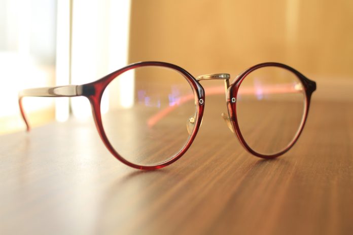 fashion eyeglasses on wooden table with light brown background eyeglass frame size