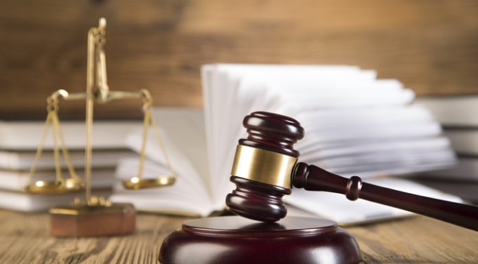 Scales of justice and Gavel on wooden table and Lawyer or Judge working with agreement in Courtroom, Justice and Law concept