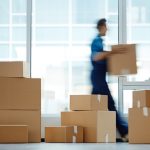 How to Find a Good International Relocation Service Company Blurred motion of contemporary worker with packed box walking to new office while delivering it to client