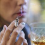 How Substance Use Can Affect Women’s Health Beautiful woman drinking a glass of whiskey and smoking a cigarette