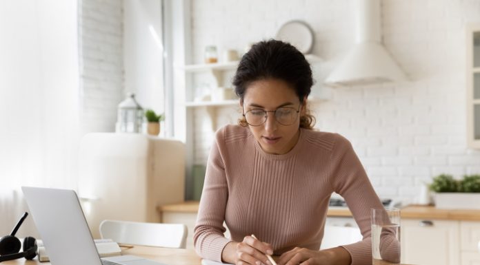 Prepare Yourself before Writing – The Most Important Tips You Should Follow Concentrated young woman in eyewear reading carefully educational handbook, improving professional knowledge or preparing for university admission exams, writing notes in copybook, learning concept.