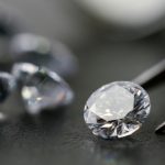 The Growth and Opportunities in the Lab-Grown Diamond Industry brilliant cut diamond held by tweezers on black background