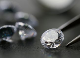 The Growth and Opportunities in the Lab-Grown Diamond Industry brilliant cut diamond held by tweezers on black background