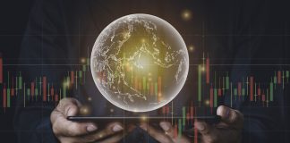 A man with tablet and a hand holding a globe graphic and stock chart Investment concepts, business concepts, technology concepts.