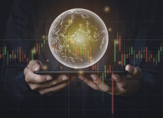 A man with tablet and a hand holding a globe graphic and stock chart Investment concepts, business concepts, technology concepts.