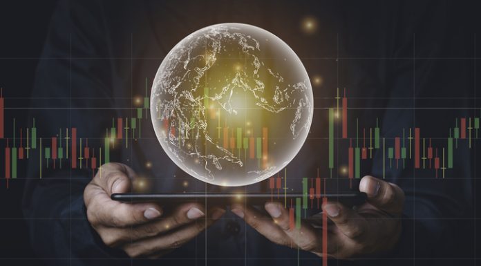 Points to Keep in Mind While Investing in Foreign Stocks A man with tablet and a hand holding a globe graphic and stock chart Investment concepts, business concepts, technology concepts.