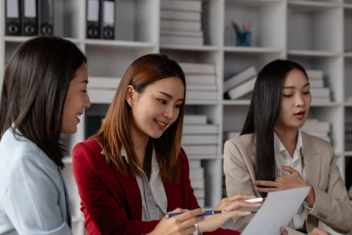 three businessperson are working in the modern office, group of employee has discussion about new project, working as teamwork is more effective, coworkers are brainstorming to planing great strategy