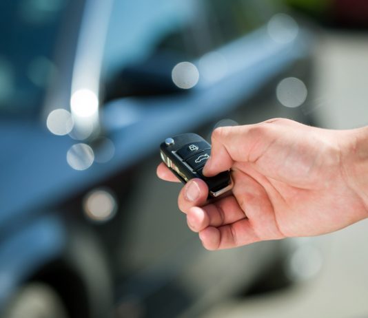 Man hand press the remote control car alarm systems