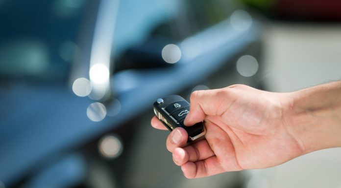 Man hand press the remote control car alarm systems