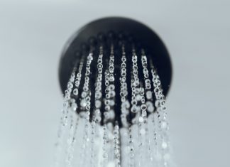 Does a Cold Shower Really Help? shower head with water drop flowing.