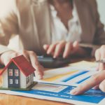 Close up hand of businesswoman signing contract Insurance protecting house.