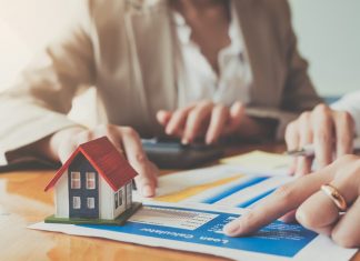 How Do Unregulated Property Loans Actually Work? Close up hand of businesswoman signing contract Insurance protecting house.