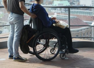 man walking with disabled gay in museum together on old histor