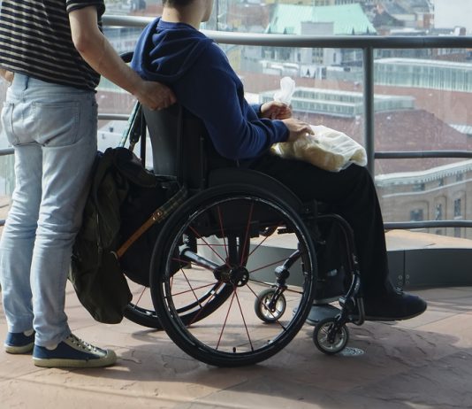 man walking with disabled gay in museum together on old histor