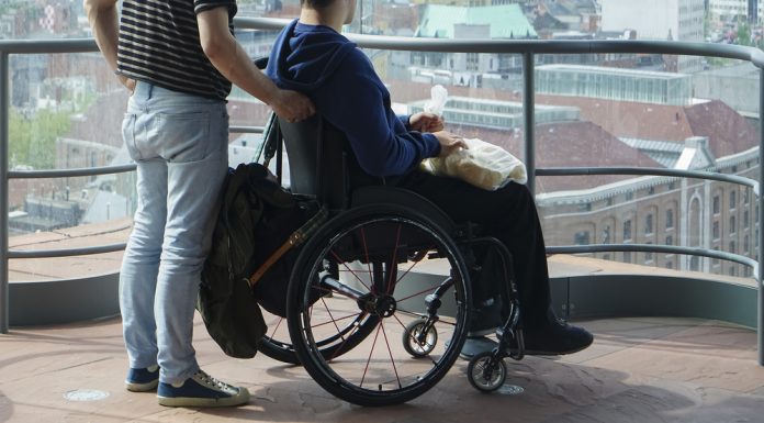 man walking with disabled gay in museum together on old histor