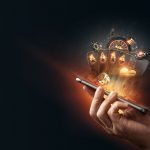 An Overview Of The Australian Casino Industry Creative background, online casino, in a man's hand a smartphone with playing cards, roulette and chips, black-gold background. Internet gambling concept. Copy space