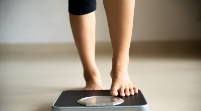 Female leg stepping on weigh scales. Healthy lifestyle, food and sport concept.