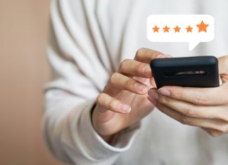 close up on customer man hand pressing on smartphone screen with gold five star rating feedback icon and press level excellent rank for giving best score point to review the service , technology business concept