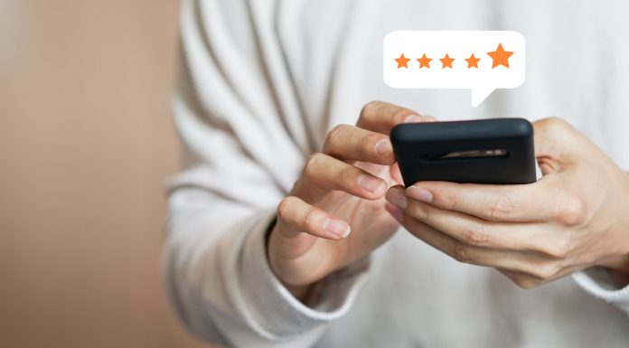 Increase Push Notification Delivery: 4 Things Mobile Brands Should Do close up on customer man hand pressing on smartphone screen with gold five star rating feedback icon and press level excellent rank for giving best score point to review the service , technology business concept