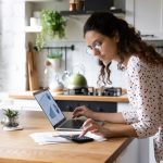 Serious woman wearing glasses calculating finances, working with project statistics