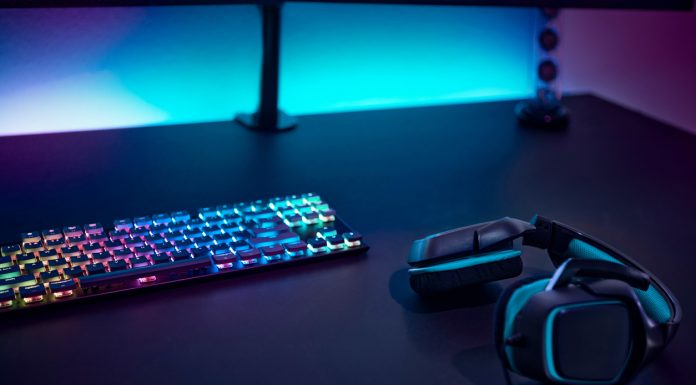 How iGaming Is Still on The Rise in New Zealand Gaming accessories on dark table. Keyboard with color backlit and stereo headphones.