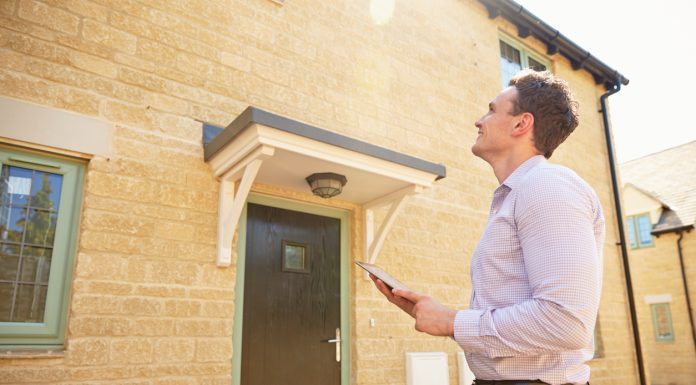 Essential Career Advice for Real Estate Agents Male real estate agent looking up at a house exterior