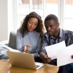Serious African American couple discussing paper documents