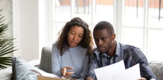 Serious African American couple discussing paper documents