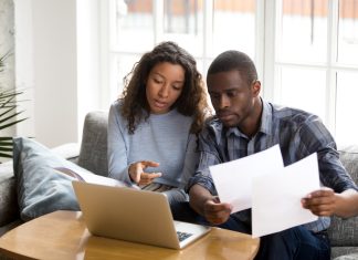 What is Behavioural Finance & How Does it Affect Your Financial Decisions? Serious African American couple discussing paper documents