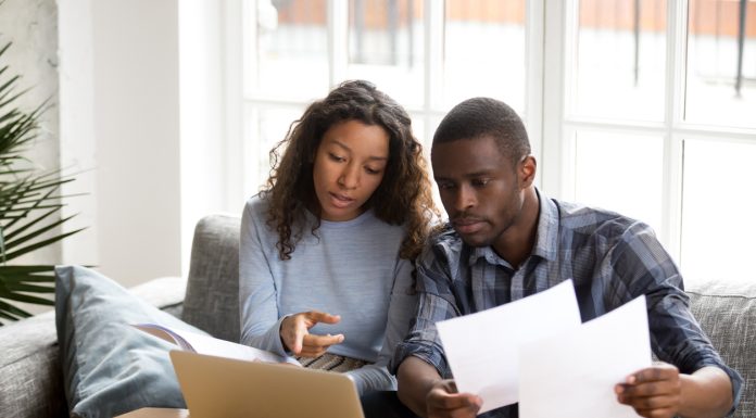 Serious African American couple discussing paper documents
