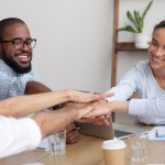 How Registered Agent LLC Services are Helping Startups Launch their Business Happy smiling corporate diverse team joining hands together showing unity