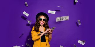 Portrait of her she nice attractive cheerful cheery positive trendy luxury wavy-haired lady throwing 100 hundred million expenses isolated over bright vivid shine violet lilac background