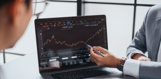 Businessman talking about investment stock market and graph from computer laptop with broker trader, giving money plan management and analysis