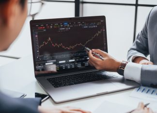 The Fundament Of Bitcoin Investment – Genuine Or Baseless Businessman talking about investment stock market and graph from computer laptop with broker trader, giving money plan management and analysis