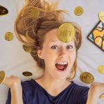 How to trade NFT tokens? NFT Young woman, a digital artist, creates digital art on a tablet at home and shows a coin with the inscription NTF - non fungible token. Remote work, digital nomad, digital painting, animation, video