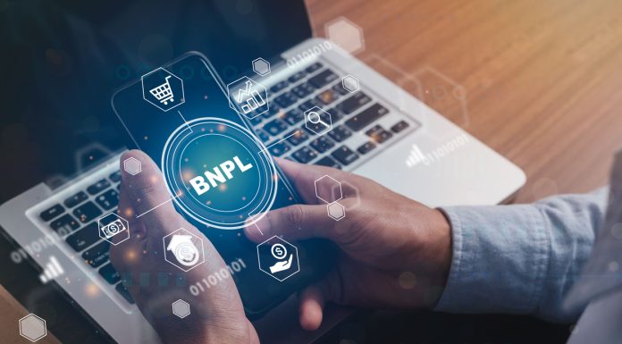 Businessmen holding a smartphone with icons of BNPL with online shopping icons technology. BNPL Buy now pay later online shopping concept.