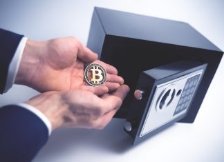 Safe Deposit. Symbol of cryptocurrency safety. The man puts a physical bitcoin in small Residential Vault. Toned soft focus picture.