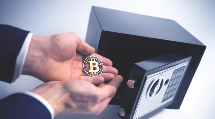 What is Bitcoin Private (BTCP)? Safe Deposit. Symbol of cryptocurrency safety. The man puts a physical bitcoin in small Residential Vault. Toned soft focus picture.
