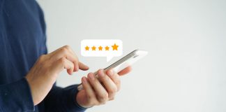 close up on customer man hand pressing on smartphone screen with five star rating feedback icon and press level good rank for giving best score point to review the service , technology business concept