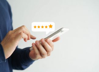 close up on customer man hand pressing on smartphone screen with five star rating feedback icon and press level good rank for giving best score point to review the service , technology business concept