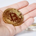 Binance vs CoinSpot – Which is the Better Exchange? Maesot, Thailand- June 5, 2021:Close-up Bitcoin in woman's hand on bright blurred background, New concept cryptocurrency virtual money is the future of digital currency online financial payments.