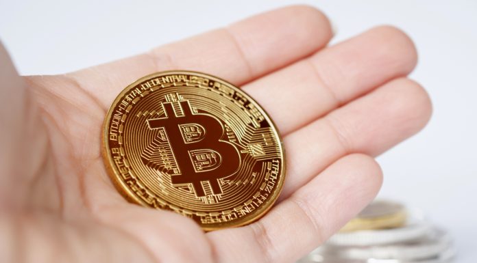 Binance vs CoinSpot – Which is the Better Exchange? Maesot, Thailand- June 5, 2021:Close-up Bitcoin in woman's hand on bright blurred background, New concept cryptocurrency virtual money is the future of digital currency online financial payments.