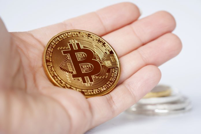 Maesot, Thailand- June 5, 2021:Close-up Bitcoin in woman's hand on bright blurred background, New concept cryptocurrency virtual money is the future of digital currency online financial payments.