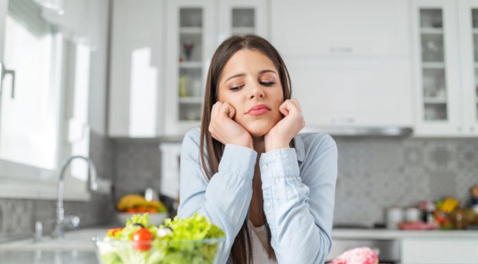 Teenage girl chooses between donuts and vegetable salad